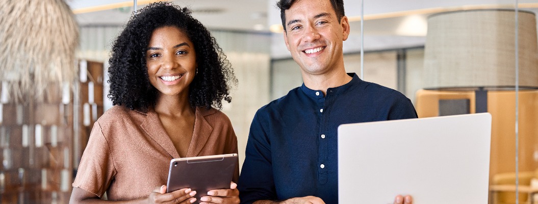 Young happy professional work team of two diverse confident female and male partners employees business people man and woman standing together in office looking at camera, corporate portrait.